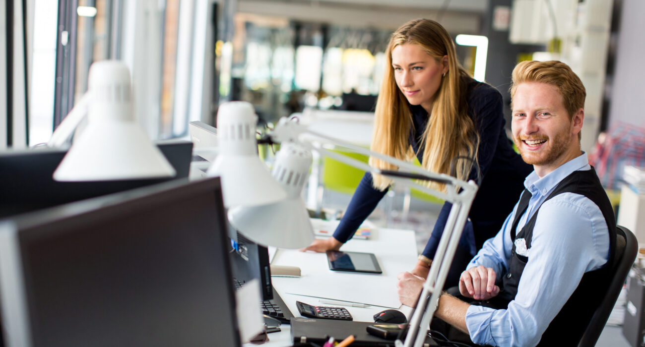 Young business couple using laptop in the office